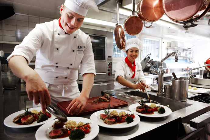 BHMS in Lucerne - students preparing a dish - credits BHMS