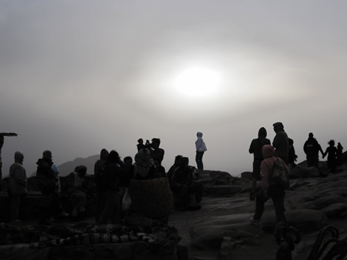 People waiting for the sun to peak through the clouds at 6:35 a.m.