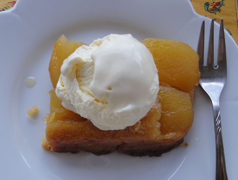 Slice of tarte tatin in a serving plate with ice-cream