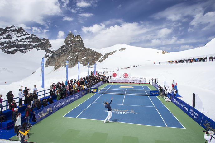 SWITZERLAND JUNGFRAUJOCH ROGER FEDERER LINDT Switzerland's champion tennis player Roger Federer and US champion ski racer Lindsey Vonn played an exhibition tennis match on the Aletsch Glacier below the Sphinx Summit to celebrate the opening of the LINDT Swiss Chocolate Heaven, a shop at 3,454 metres above sea level on Jungfraujoch, Switzerland, on Tuesday, July 16, 2014. The themed chocolate shop, which offers a wide range of the finest LINDT chocolate and the adjacent Master Chocolatiers parlor gives visitors a insight into how chocolate is made, was opened by Roger Federer and is collaboration between Swiss chocolate maker Lindt & Spruengli AG and Jungfrau Railway Holding AG. (PHOTOPRESS/Alexandra Wey) 